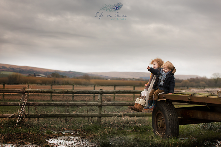 children on farm trailer in field