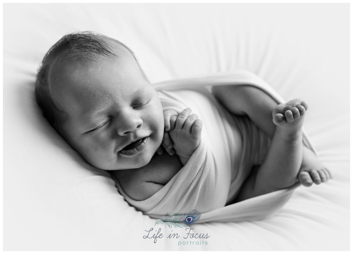 black and white photo of smiling newborn Simply Baby sessions Life in Focus Portraits newborn portrait specialist Rhu Helensburgh