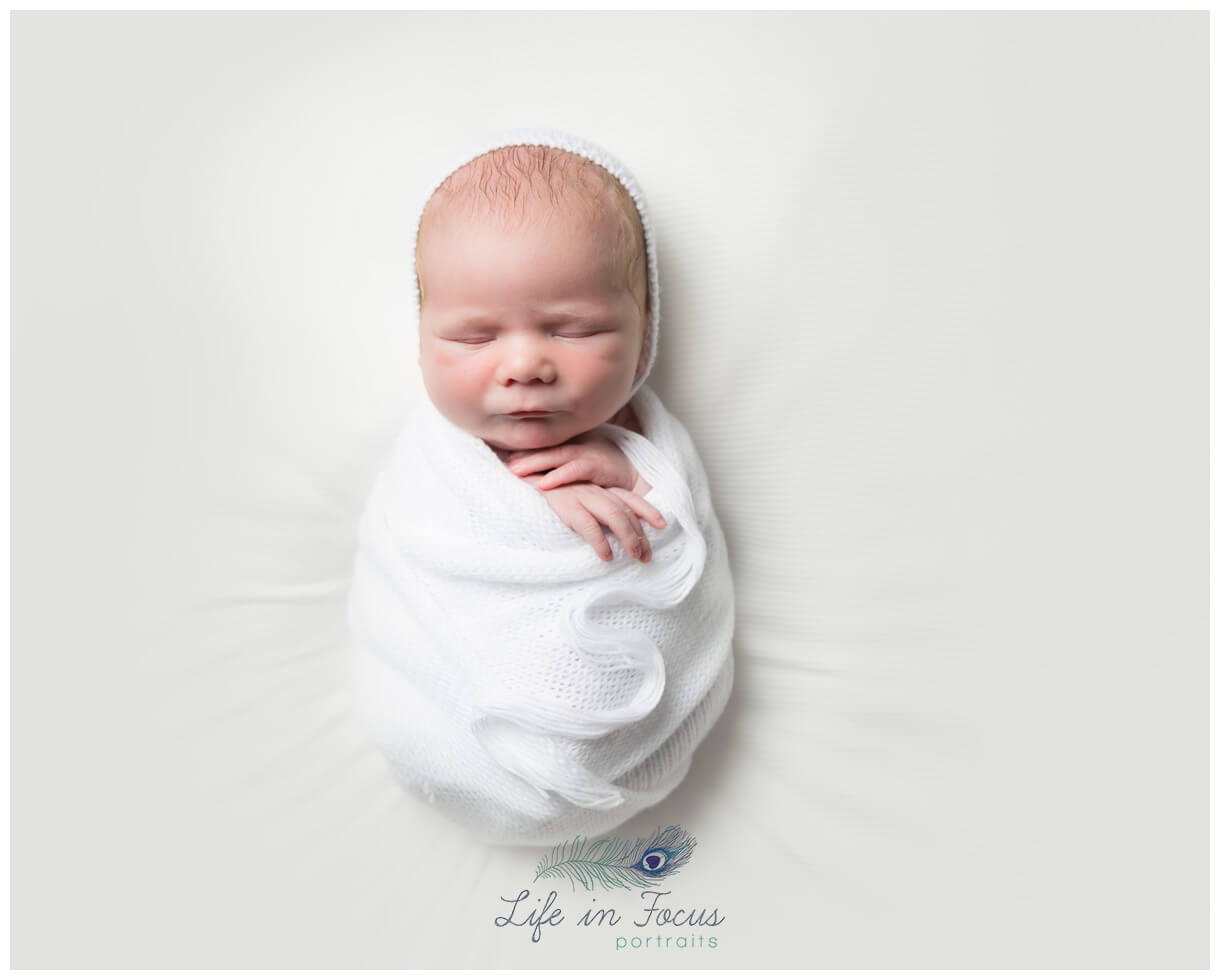 newborn baby in white bonnet and wrap Life in Focus Portraits Simply Baby newbonr mini sessions Rhu Helensburgh