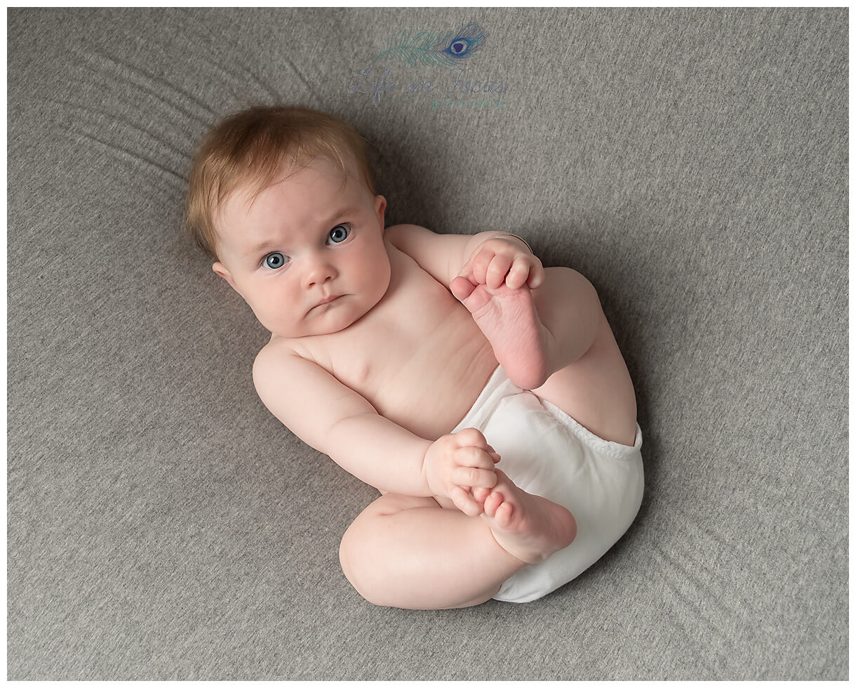 photo of baby playing with feet Life in Focus Portraits baby photoshoots Rhu Helensburgh Cardross