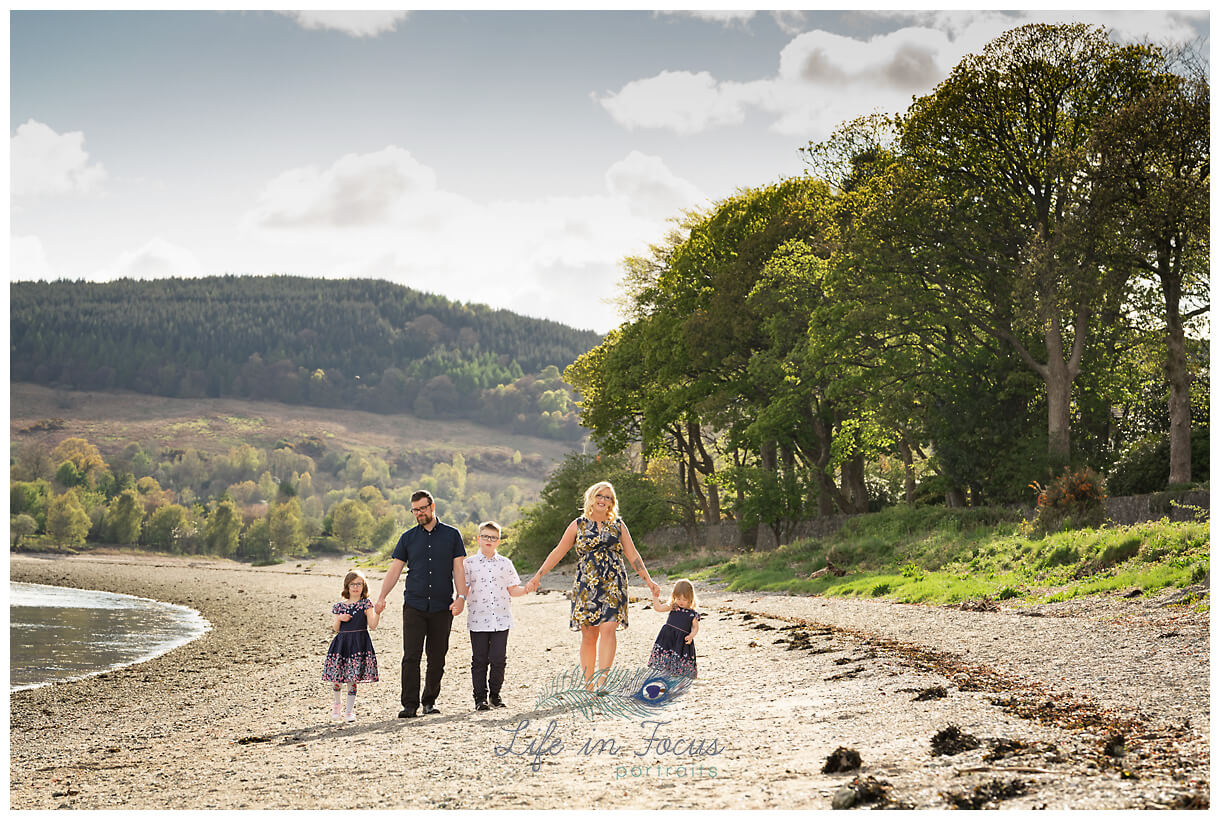 photo of family waling hand in hand along beach rho outdoor photographer