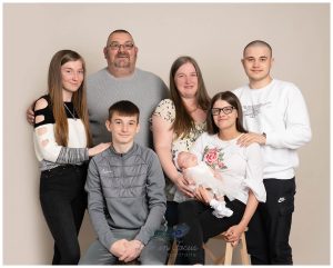 photo of family with new baby and grandparents on cream backdrop in studio Helensburgh photo studio